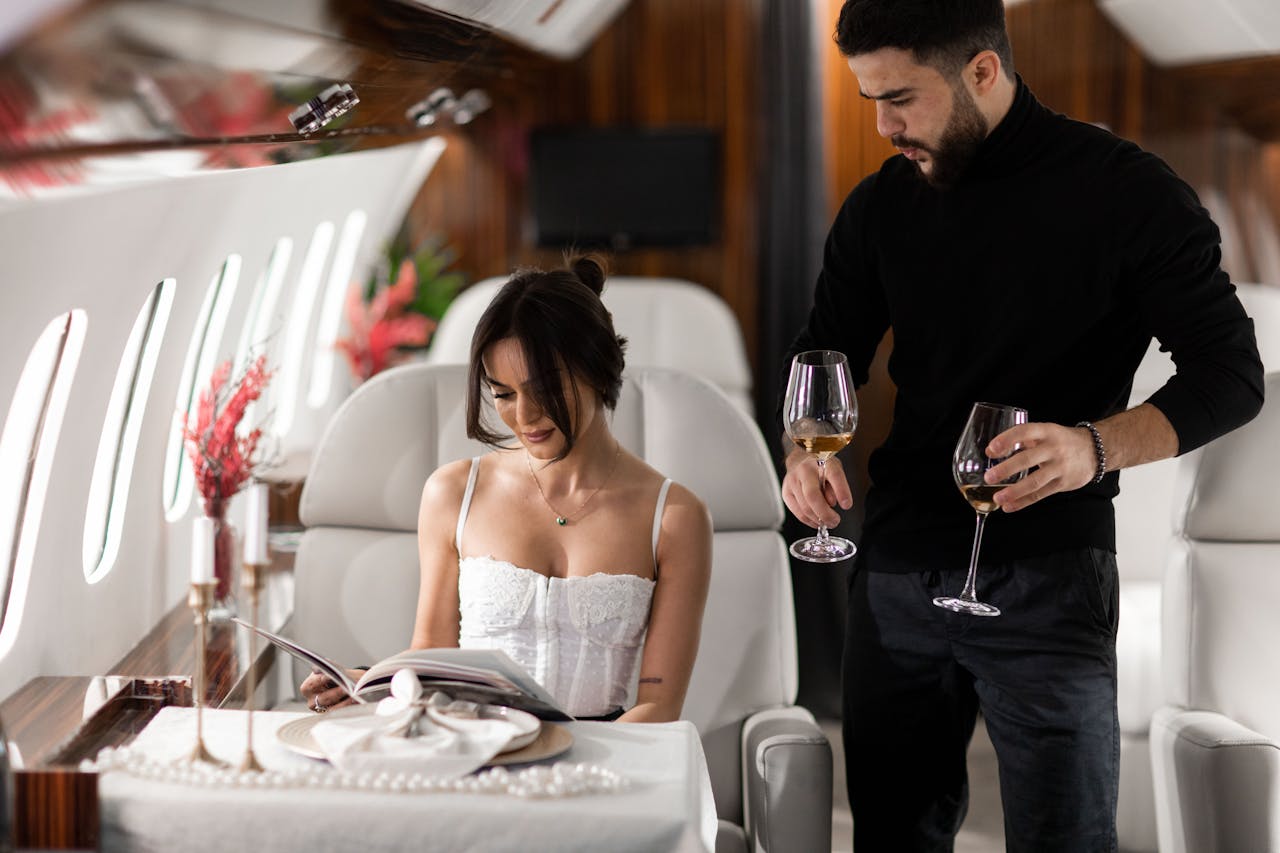services-02 Elegant couple enjoying wine in a luxurious private jet interior.