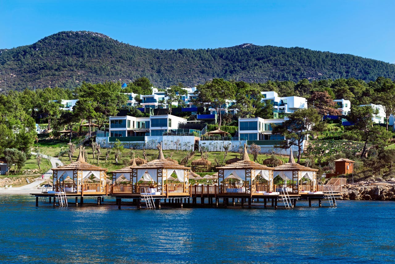 gallery-5 Beautiful seaside resort featuring cabanas and villas by the lush hillside.